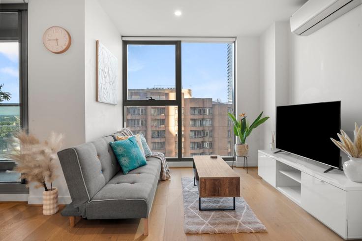Elegante sala de estar con mobiliario moderno en un apartamento en Building La Trobe Street - live-luxe - 1646008 en Melbourne, Melbourne
