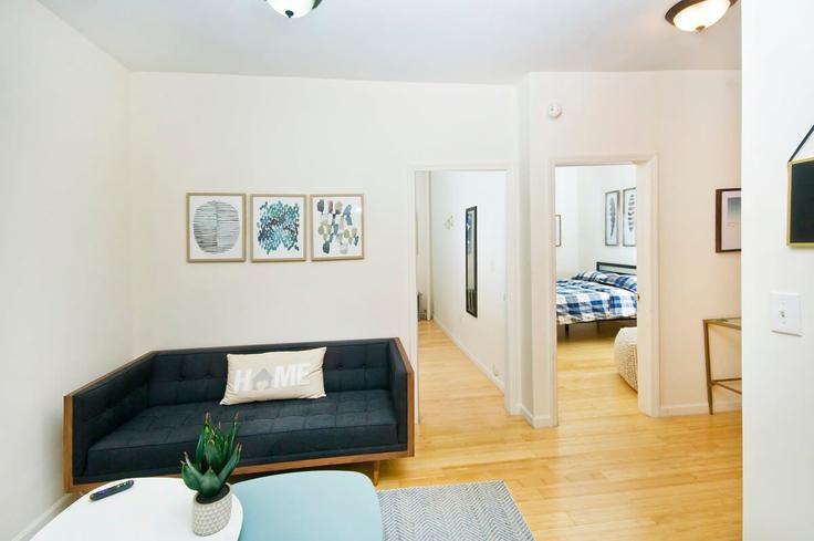 Sala de estar elegantemente projetada com móveis modernos em um apartamento no Building East 102nd Street - livly-housing - 1245619 - NYC em Manhattan, New York Sala de estar elegantemente projetada com móveis modernos em um apartamento no Building East 102nd Street - livly-housing - 1245619 - NYC em Manhattan, New York