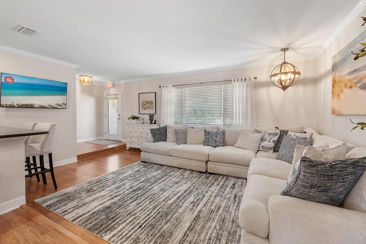 Sala de estar elegantemente projetada com móveis modernos em um apartamento no Building Christopher Court - livly-housing - 1245873 - USA em Palm Coast, Palm Coast