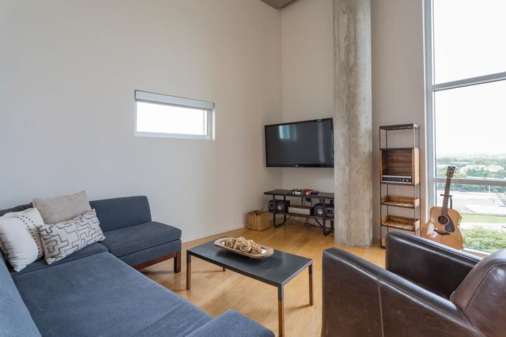 Sala de estar elegantemente projetada com móveis modernos em um apartamento no Building Yeaman Place - livly-housing - 1247566 - BNA em Nashville, Nashville Sala de estar elegantemente projetada com móveis modernos em um apartamento no Building Yeaman Place - livly-housing - 1247566 - BNA em Nashville, Nashville
