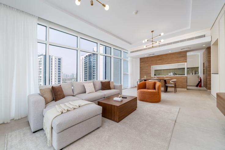 Sala de estar elegantemente projetada com móveis modernos em um apartamento no Building Cluster W - luxfolio-retreats-1 - 1604891 em Al Thanyah Fifth, Dubai