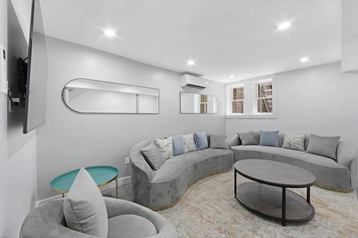Sala de estar elegantemente projetada com móveis modernos em um apartamento no Building West 182nd Street - max-lux-rentals - 1302125 em Manhattan, New York Sala de estar elegantemente projetada com móveis modernos em um apartamento no Building West 182nd Street - max-lux-rentals - 1302125 em Manhattan, New York
