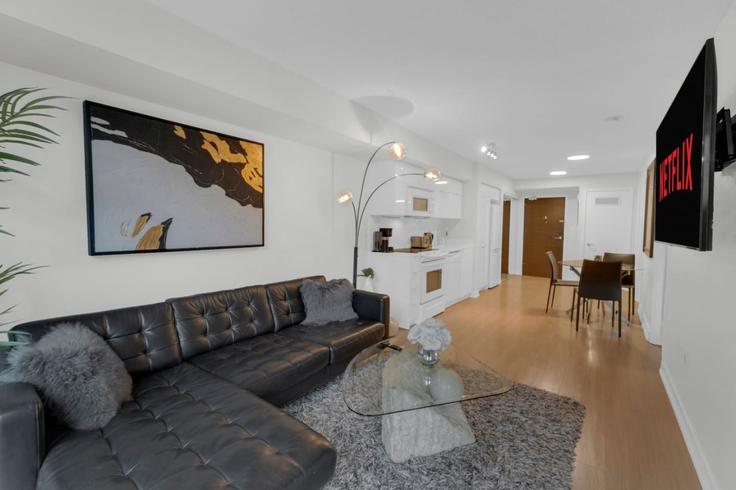 Sala de estar elegantemente projetada com móveis modernos em um apartamento no Building Dan Leckie Way - maxima-properties - 1403760 em Old Toronto, Toronto