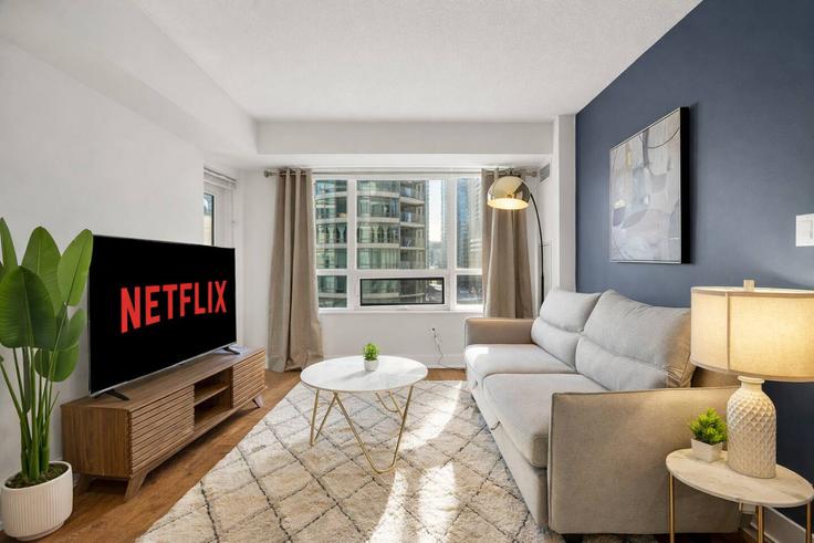Sala de estar elegantemente projetada com móveis modernos em um apartamento no Building Blue Jays Way - maxima-properties - 1403814 em Old Toronto, Toronto