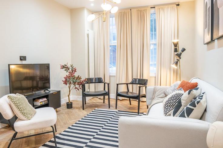 Sala de estar elegantemente projetada com móveis modernos em um apartamento no Building 38 Fingal St, London, UK - murray-stays-limited - 1647396 em Royal Borough of Greenwich, London