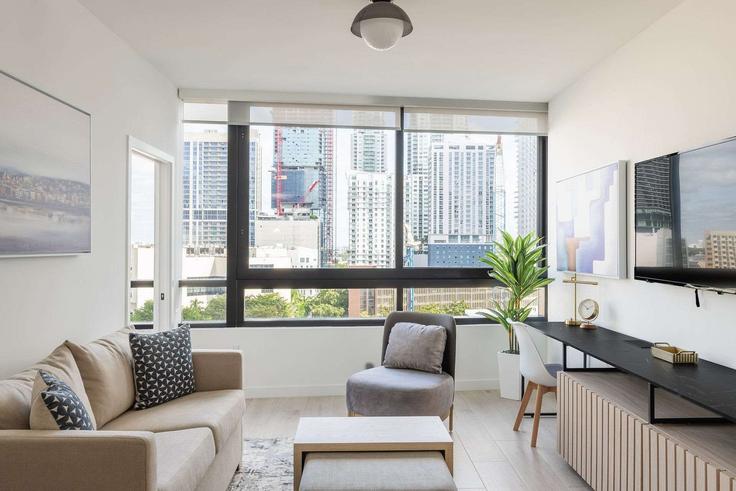 Sala de estar elegantemente projetada com móveis modernos em um apartamento no Building North Miami Avenue - nomadaresidences - 1515063 em Miami, Miami