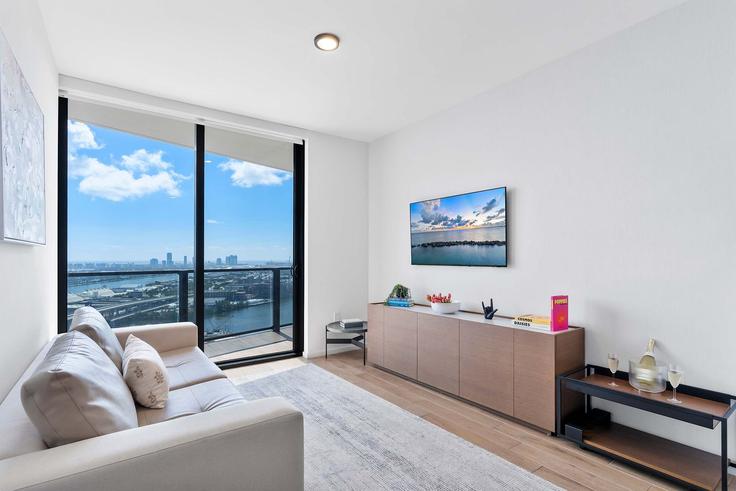 Sala de estar elegantemente projetada com móveis modernos em um apartamento no Building Northeast 5th Street - oasis - 1578702 em Miami, Miami Sala de estar elegantemente projetada com móveis modernos em um apartamento no Building Northeast 5th Street - oasis - 1578702 em Miami, Miami