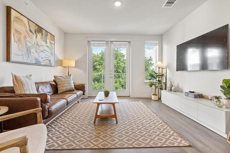 Sala de estar elegantemente projetada com móveis modernos em um apartamento no Building Cameron Road - oh-management-usa-llc - 1303393 em Austin, Austin