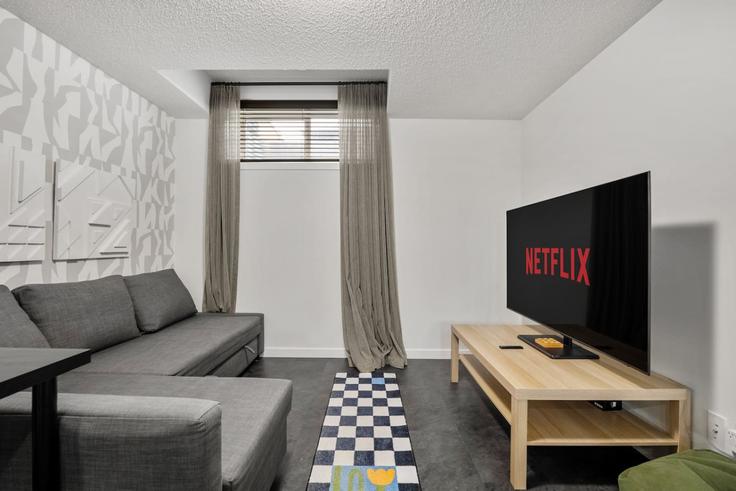 Sala de estar elegantemente projetada com móveis modernos em um apartamento no Building Ambleside Heath Northwest - premier-stays - 1343913 em Calgary, Calgary Sala de estar elegantemente projetada com móveis modernos em um apartamento no Building Ambleside Heath Northwest - premier-stays - 1343913 em Calgary, Calgary