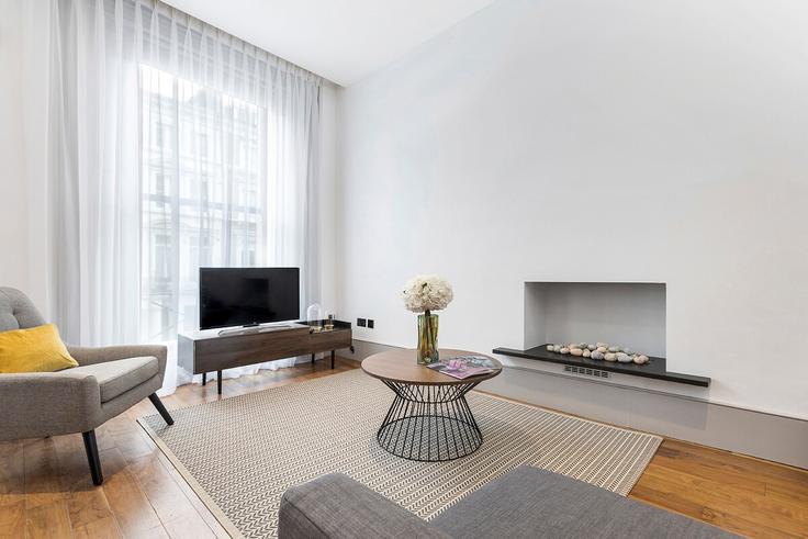 Sala de estar elegantemente projetada com móveis modernos em um apartamento no Building Collingham Place - pvl-properties-ltd - 1341829 em Royal Borough of Kensington and Chelsea, London Sala de estar elegantemente projetada com móveis modernos em um apartamento no Building Collingham Place - pvl-properties-ltd - 1341829 em Royal Borough of Kensington and Chelsea, London