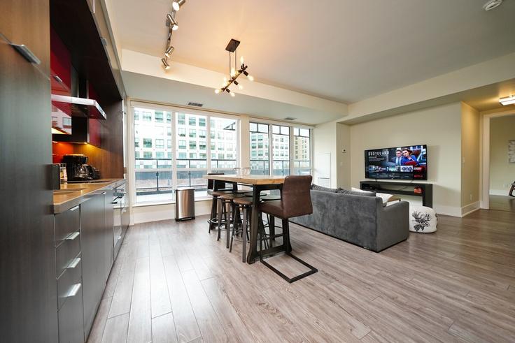 Sala de estar elegantemente projetada com móveis modernos em um apartamento no Building Front Street West - rivetstays-ontario-inc - 1297517 - TOR em Old Toronto, Toronto Sala de estar elegantemente projetada com móveis modernos em um apartamento no Building Front Street West - rivetstays-ontario-inc - 1297517 - TOR em Old Toronto, Toronto
