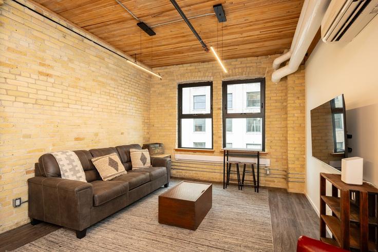 Salle de séjour élégante avec mobilier moderne dans un appartement à Building Market Avenue - roam-rentals - 1644186 à Winnipeg, Winnipeg