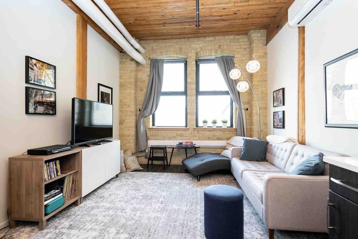 Elegante sala de estar con mobiliario moderno en un apartamento en Building Market Avenue - roam-rentals - 1644159 en Winnipeg, Winnipeg