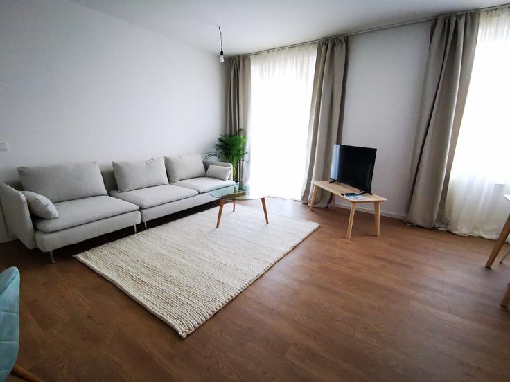 Elegantly designed living room with modern furnishings in an apartment at Building Helene-Jacobs-Straße - rockchair-gmbh - 1512914 in Berlin, Berlin