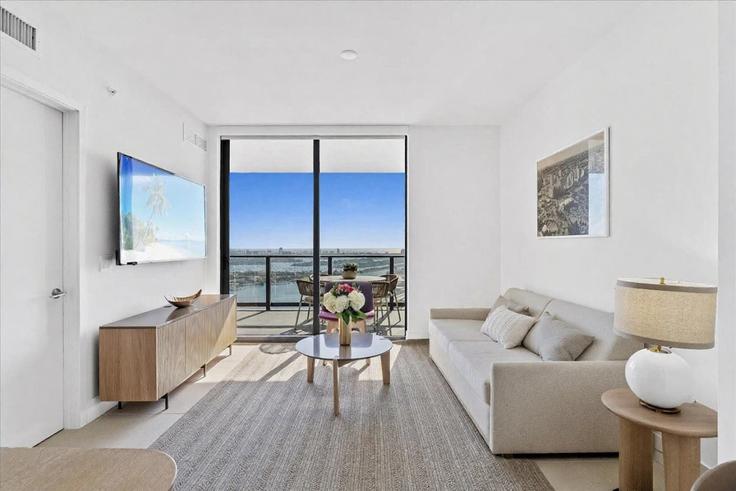 Sala de estar elegantemente projetada com móveis modernos em um apartamento no Building Northeast 1st Avenue - seker-management - 1648189 em Miami, Miami Sala de estar elegantemente projetada com móveis modernos em um apartamento no Building Northeast 1st Avenue - seker-management - 1648189 em Miami, Miami