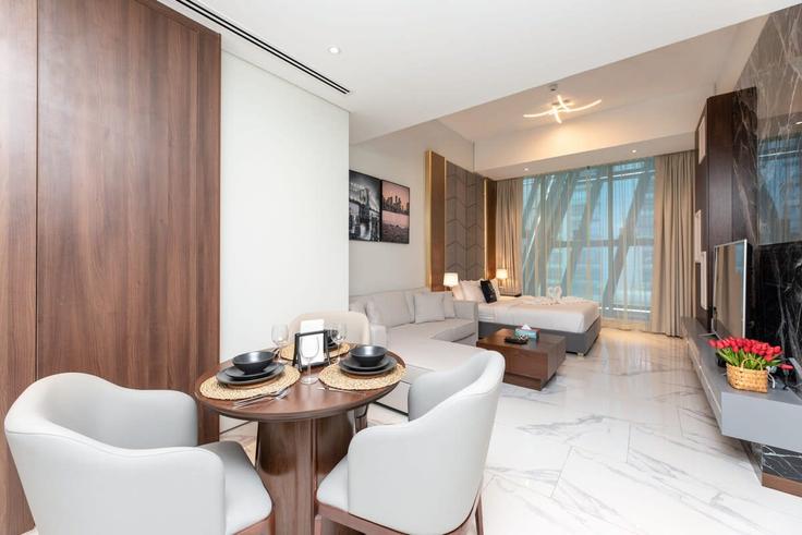 Sala de estar elegantemente projetada com móveis modernos em um apartamento no Building Marasi Drive - simplycomfortsuites - 1261522 - DXB em Business Bay, Dubai