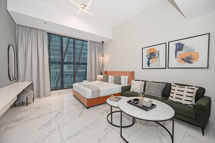 Sala de estar elegantemente projetada com móveis modernos em um apartamento no Building Marasi Drive - stay-local-holiday-homes - 1475629 em Business Bay, Dubai
