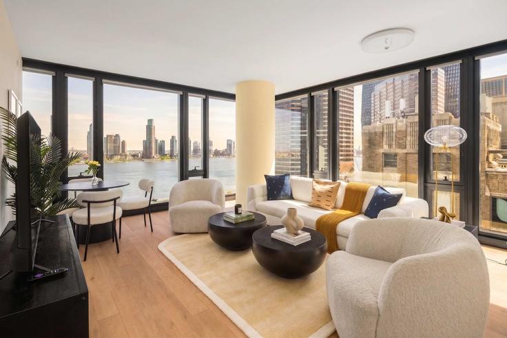 Sala de estar elegantemente projetada com móveis modernos em um apartamento no Building 1st Avenue - stayhausguesty - 1541441 em Manhattan, New York Sala de estar elegantemente projetada com móveis modernos em um apartamento no Building 1st Avenue - stayhausguesty - 1541441 em Manhattan, New York