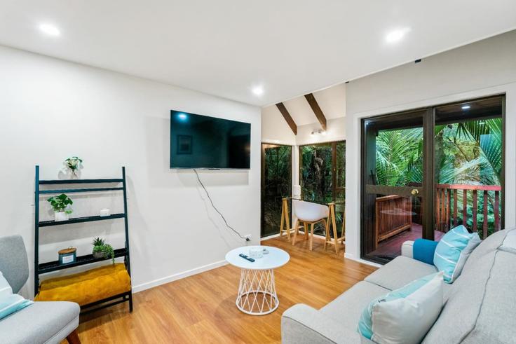 Sala de estar elegantemente projetada com móveis modernos em um apartamento no Building Kaurimu Rise - stayhub - 1291922 - NZL em Titirangi, Auckland Sala de estar elegantemente projetada com móveis modernos em um apartamento no Building Kaurimu Rise - stayhub - 1291922 - NZL em Titirangi, Auckland