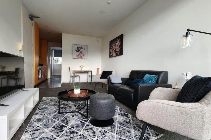 Sala de estar elegantemente projetada com móveis modernos em um apartamento no Building Fisher-Point Drive - stayhub - 1291937 - NZL em Auckland Central, Auckland