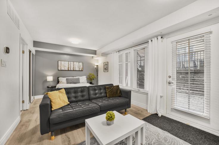 Sala de estar elegantemente projetada com móveis modernos em um apartamento no Building East Liberty Street - stayrentx - 1388889 em Old Toronto, Toronto Sala de estar elegantemente projetada com móveis modernos em um apartamento no Building East Liberty Street - stayrentx - 1388889 em Old Toronto, Toronto