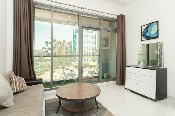 Sala de estar elegantemente projetada com móveis modernos em um apartamento no Building Al A'amal Street - stonetree-vacation-homes - 1316977 - DXB em Business Bay, Dubai
