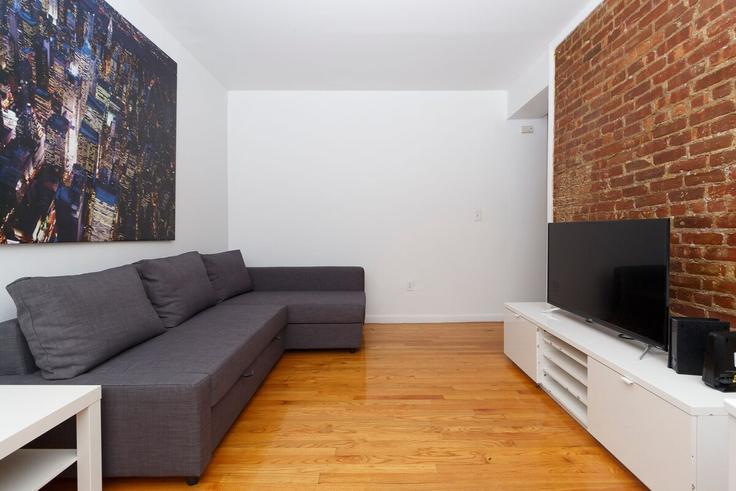 Sala de estar elegantemente projetada com móveis modernos em um apartamento no Building 2nd Avenue - thelocalstay - 1032028 - NYC em Manhattan, New York Sala de estar elegantemente projetada com móveis modernos em um apartamento no Building 2nd Avenue - thelocalstay - 1032028 - NYC em Manhattan, New York