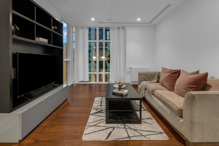 Sala de estar elegantemente projetada com móveis modernos em um apartamento no Building Indescon Square - thesquare-serviced-apartments - 1271964 - LON em London Borough of Tower Hamlets, London Sala de estar elegantemente projetada com móveis modernos em um apartamento no Building Indescon Square - thesquare-serviced-apartments - 1271964 - LON em London Borough of Tower Hamlets, London
