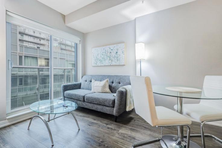 Sala de estar elegantemente projetada com móveis modernos em um apartamento no Building Richmond Street West - to-stays-inc - 1471498 em Old Toronto, Toronto Sala de estar elegantemente projetada com móveis modernos em um apartamento no Building Richmond Street West - to-stays-inc - 1471498 em Old Toronto, Toronto