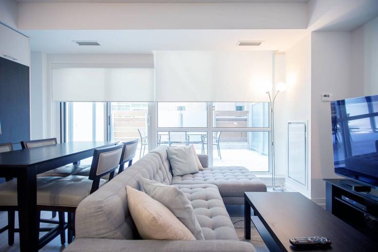 Sala de estar elegantemente projetada com móveis modernos em um apartamento no Building Richmond Street West - to-stays-inc - 1579053 em Old Toronto, Toronto