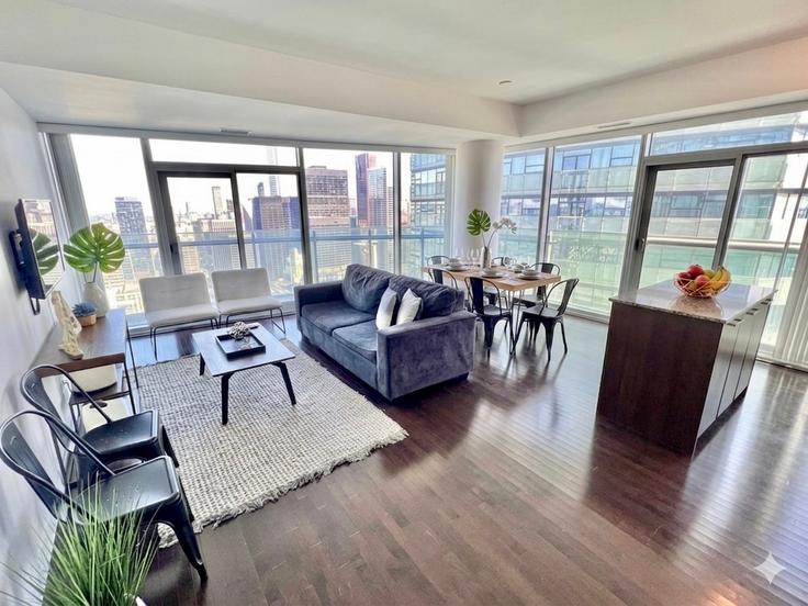 Sala de estar elegantemente projetada com móveis modernos em um apartamento no Building Bremner Boulevard - toronto-luxe - 1608967 em Old Toronto, Toronto