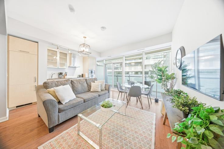 Sala de estar elegantemente projetada com móveis modernos em um apartamento no Building Bremner Boulevard - toronto-luxe - 1609070 em Old Toronto, Toronto