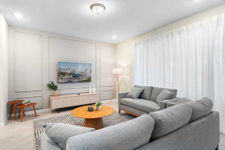 Elegante sala de estar con mobiliario moderno en un apartamento en Building Blue Paradise Way - une-homes - 1280983 - MCO en Four Corners, Four Corners