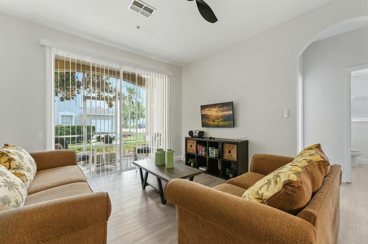 Elegante sala de estar con mobiliario moderno en un apartamento en Building Coconut Palm Way - une-homes - 1280959 - MCO en Four Corners, Four Corners