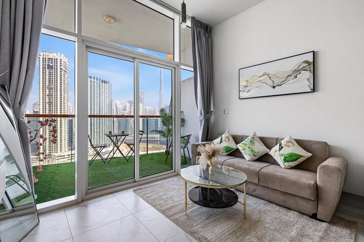 Sala de estar elegantemente projetada com móveis modernos em um apartamento no Building Marasi Drive - unlock-holiday-homes - 1475403 em Business Bay, Dubai