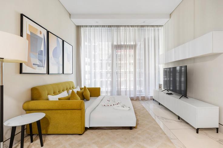 Elegante sala de estar con mobiliario moderno en un apartamento en Building Marasi Drive - unlock-holiday-homes - 1239688 - DXB en Business Bay, Dubai