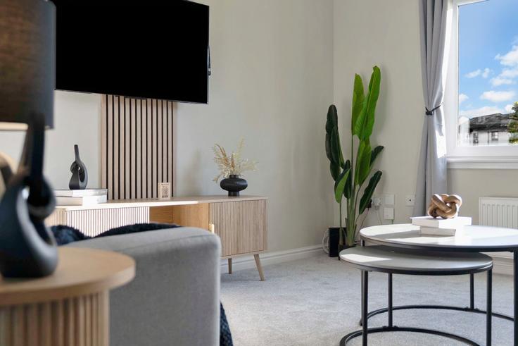 Salle de séjour élégante avec mobilier moderne dans un appartement à Building Trondheim Parkway West - vacant-nests - 1351381 à Abbeyview Dunfermline, Dunfermline