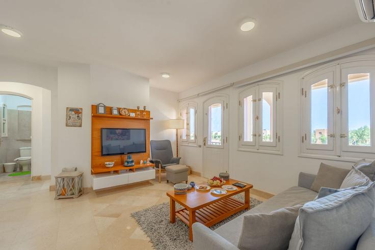 Sala de estar elegantemente projetada com móveis modernos em um apartamento no Building Upper Nubia - vesta-hospitality - 1639386 em Hurghada 2, Red Sea