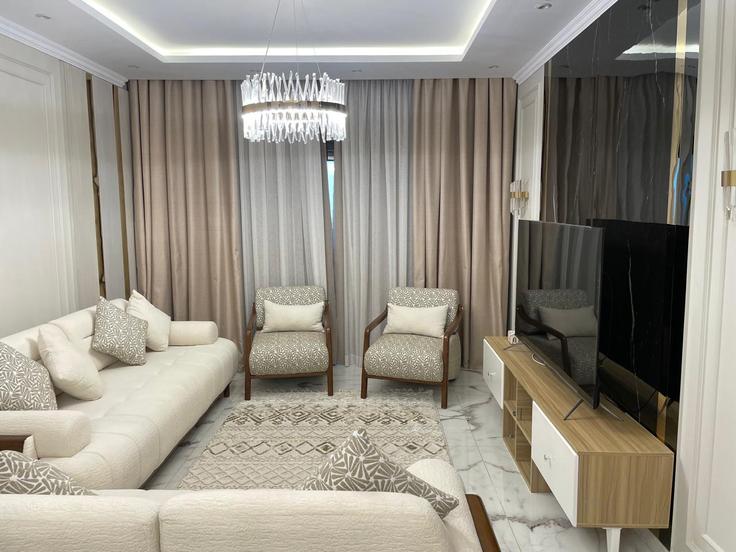 Sala de estar elegantemente projetada com móveis modernos em um apartamento no Building El Nasr - vesta-hospitality - 1634747 em New Cairo 3, Cairo