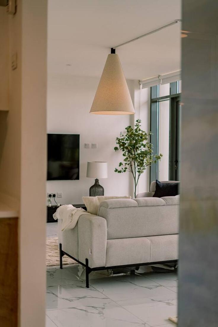 Elegante sala de estar con mobiliario moderno en un apartamento en Building Ar Rahah Street - voyage-vacation-home-rental-llc - 1286935 - DXB en Al Rahah, Abu Dhabi Elegante sala de estar con mobiliario moderno en un apartamento en Building Ar Rahah Street - voyage-vacation-home-rental-llc - 1286935 - DXB en Al Rahah, Abu Dhabi