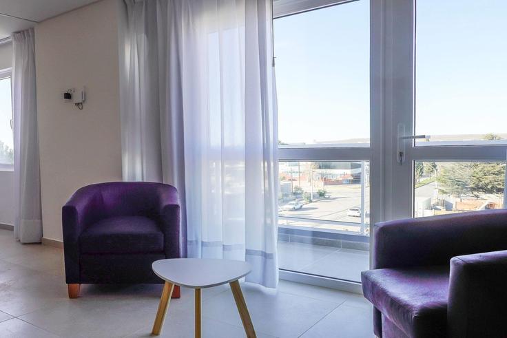 Salle de séjour élégante avec mobilier moderne dans un appartement à Building Love Parry - wyndham - 1679351 à Puerto Madryn, Puerto Madryn