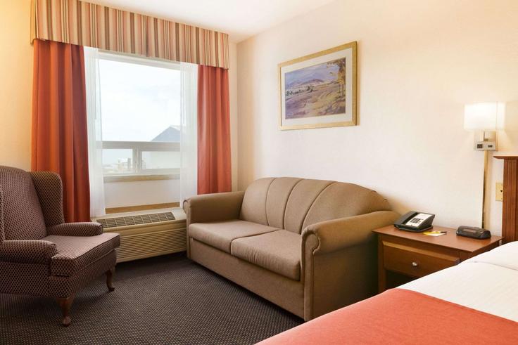 Elegant gestaltetes Wohnzimmer mit moderner Einrichtung in einer Wohnung im Building 50 Street - wyndham - 1676355 in Drayton Valley, Drayton Valley Elegant gestaltetes Wohnzimmer mit moderner Einrichtung in einer Wohnung im Building 50 Street - wyndham - 1676355 in Drayton Valley, Drayton Valley