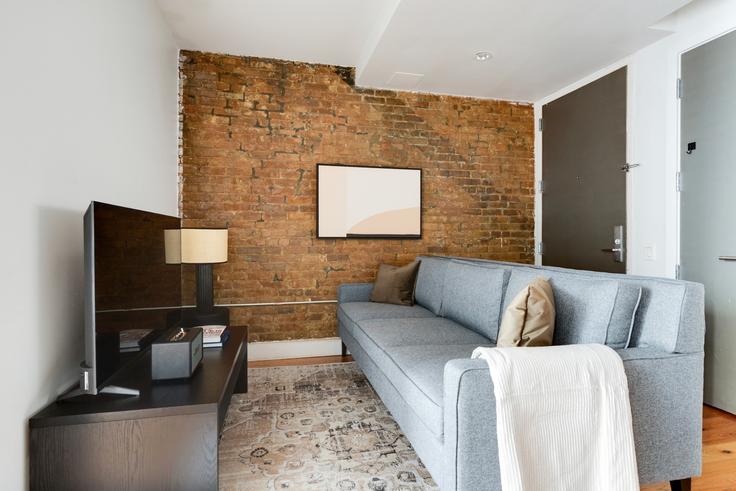 Elegant gestaltetes Wohnzimmer mit moderner Einrichtung in einer Wohnung im 72W Lofts in Brooklyn, New York