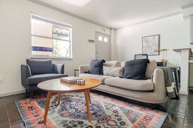 Sala de estar elegantemente projetada com móveis modernos em um apartamento no Railyard em Austin, Austin Sala de estar elegantemente projetada com móveis modernos em um apartamento no Railyard em Austin, Austin