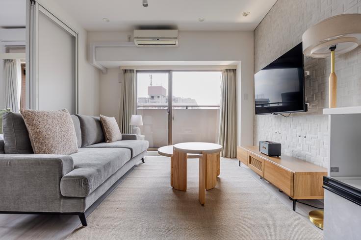 Elegante sala de estar con mobiliario moderno en un apartamento en Prime Urban Meguro Riverfront en Meguro City, Tokyo Elegante sala de estar con mobiliario moderno en un apartamento en Prime Urban Meguro Riverfront en Meguro City, Tokyo