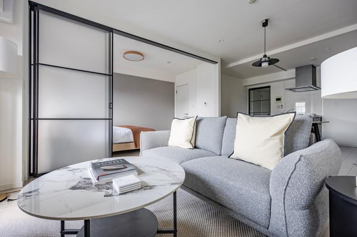 Elegante sala de estar con mobiliario moderno en un apartamento en Prime Urban Meguro Riverfront en Meguro City, Tokyo Elegante sala de estar con mobiliario moderno en un apartamento en Prime Urban Meguro Riverfront en Meguro City, Tokyo