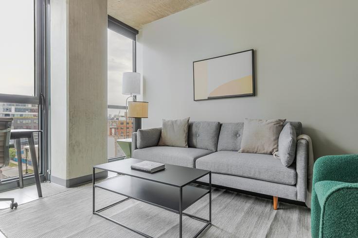 Sala de estar elegantemente projetada com móveis modernos em um apartamento no The Mason em Chicago, Chicago Sala de estar elegantemente projetada com móveis modernos em um apartamento no The Mason em Chicago, Chicago