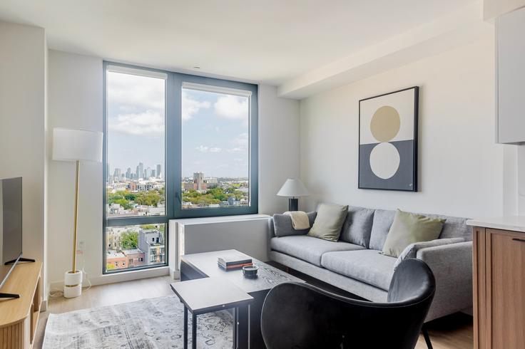 Elegant gestaltetes Wohnzimmer mit moderner Einrichtung in einer Wohnung im The Welz in Brooklyn, New York Elegant gestaltetes Wohnzimmer mit moderner Einrichtung in einer Wohnung im The Welz in Brooklyn, New York