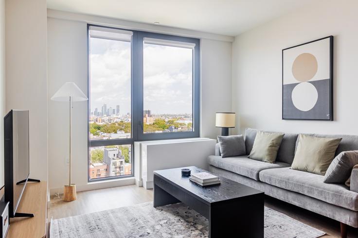Elegant gestaltetes Wohnzimmer mit moderner Einrichtung in einer Wohnung im The Welz in Brooklyn, New York Elegant gestaltetes Wohnzimmer mit moderner Einrichtung in einer Wohnung im The Welz in Brooklyn, New York