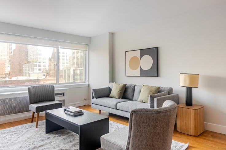 Elegante sala de estar con mobiliario moderno en un apartamento en Stonehenge 65 en Manhattan, New York